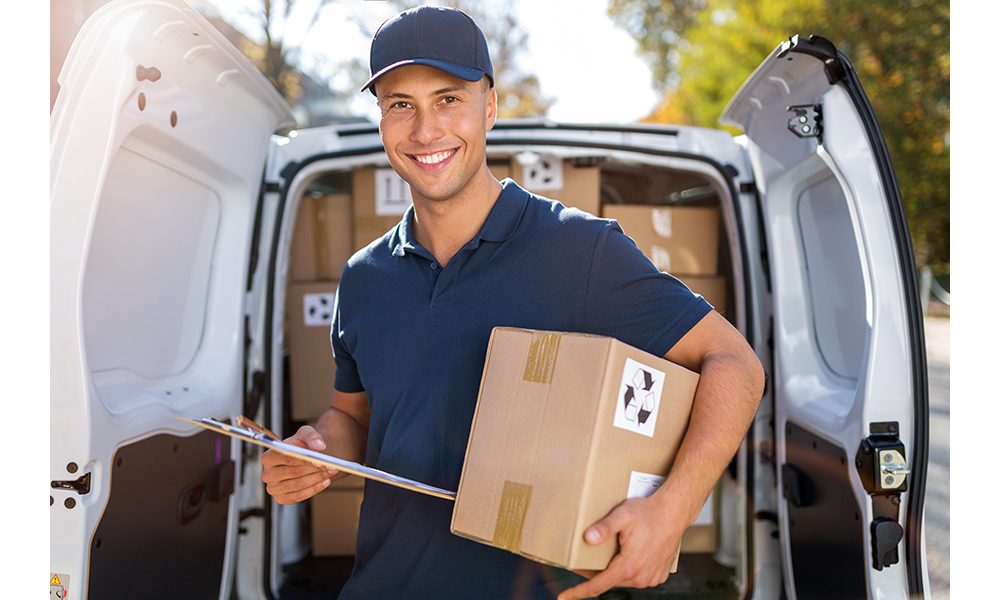 Delivery man standing in front of his van
