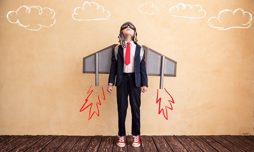 Portrait of young businessman with toy paper wings. Success, creative and startup concept. Copy space for your text