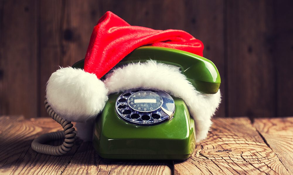 vintage phone with Santa's hat on wooden background