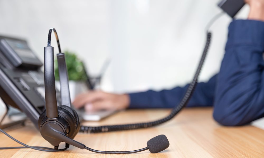 Call center staff man hand point to press the button number on the phone office desk , Communication support, call center and customer service help desk. for (call center) concept