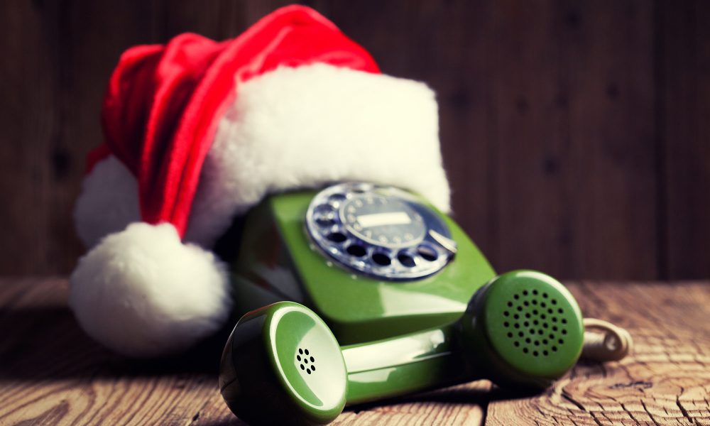 vintage phone with Santa's hat on wooden background